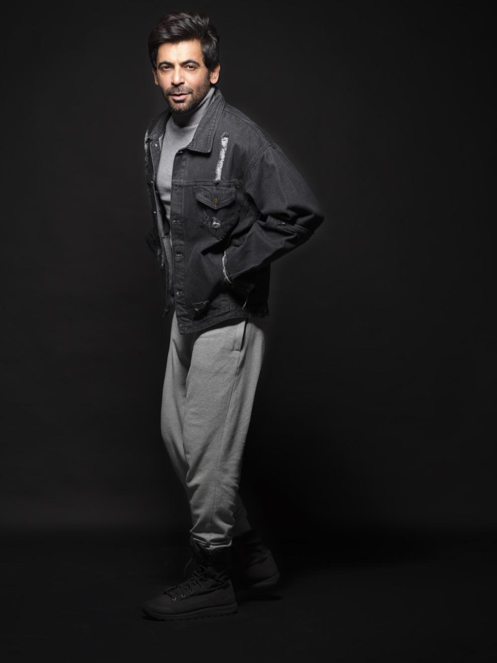 Sunil Grover in black denim against a black studio backdrop