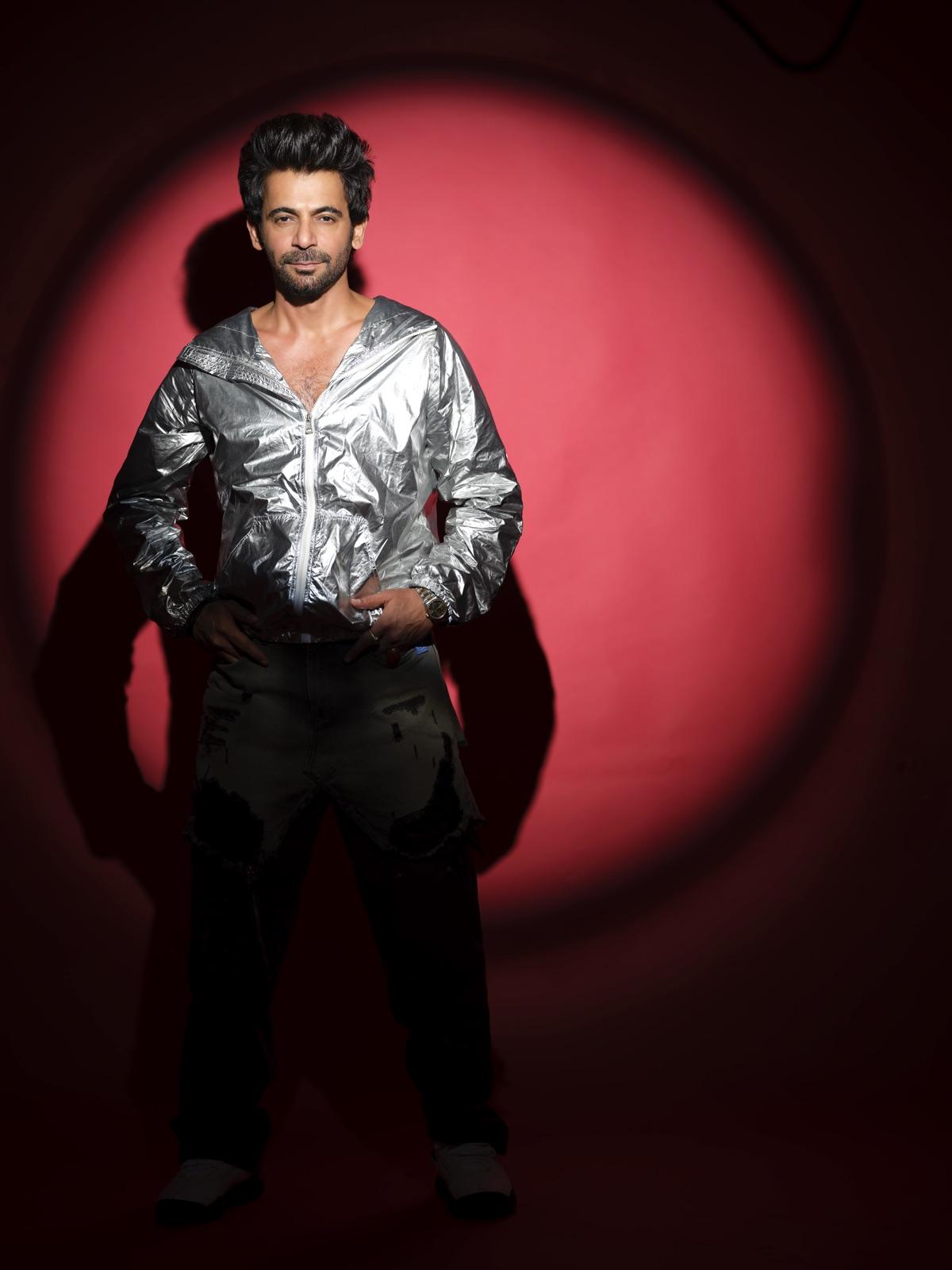 Sunil Grover in a silver jacket, lit by a single red spotlight